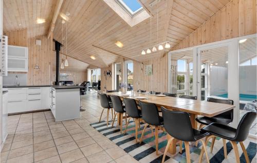 a kitchen with a long wooden table and chairs at Gorgeous Home In Ringkøbing With Sauna in Søndervig