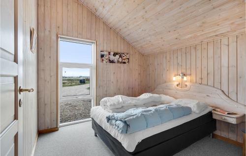 a bedroom with a bed in a room with a window at Gorgeous Home In Ringkøbing With Sauna in Søndervig