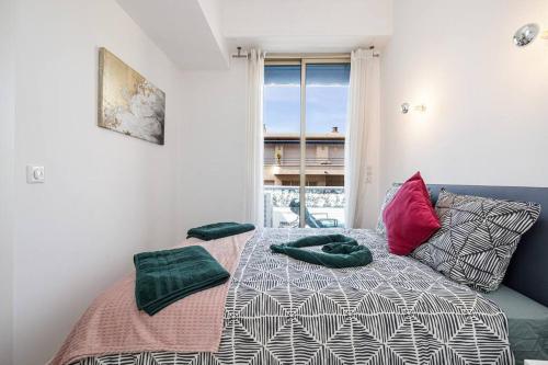 une chambre avec un lit avec des oreillers et une fenêtre dans l'établissement Royal Riviera, à Nice