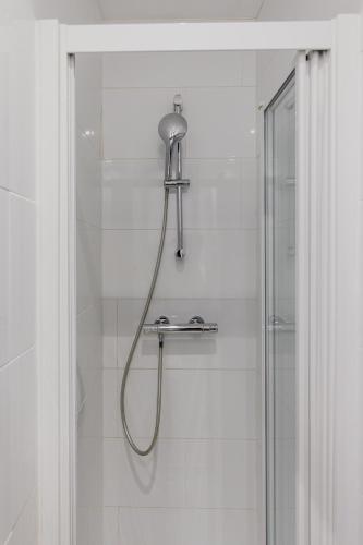 une douche avec pommeau de douche dans une salle de bain dans l'établissement Cosy studio - 2P - Sentier, à Paris