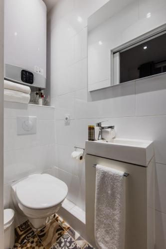 une salle de bain blanche avec des toilettes et un lavabo dans l'établissement Cosy studio - 2P - Sentier, à Paris