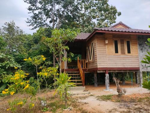 une petite maison en bois avec un porche et des escaliers pour y accéder dans l'établissement Relax House, à Ko Phayam