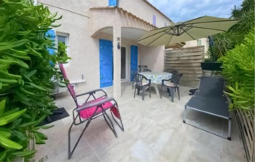 un patio avec une table, des chaises et un parasol dans l'établissement Stunning Home In La Londe Les Maures, à La Londe-les-Maures