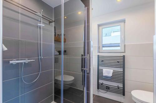 a bathroom with a shower with a toilet and a sink at Ferienhaus Charlotta mit Terrasse in Waren