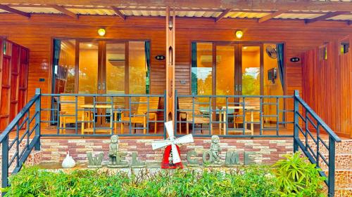 una casa con terraza con sillas y mesas en Aow Thai Homestay, en Ban Hin Dam