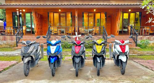 una fila de motocicletas estacionadas frente a una casa en Aow Thai Homestay, en Ban Hin Dam