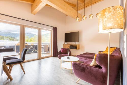 a living room with purple furniture and a large window at Apartments Kreischberg Chalets by ALPS RESORTS in Sankt Lorenzen ob Murau