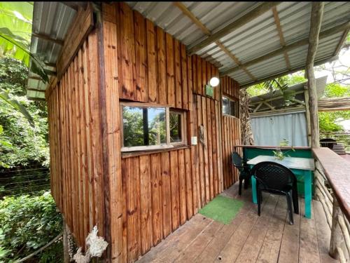 a wooden house with a desk on a deck at Mantis and Moon Surf Paradise & Adventure Lodge in Hibberdene