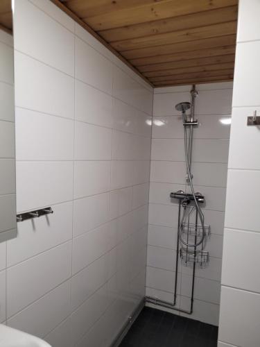 La salle de bains est pourvue d'une douche et de murs carrelés blancs. dans l'établissement Vuosselin Tähti, à Ruka