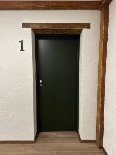 a black door in a room with the number at Apartamenty pod Belkami in Mikołajki