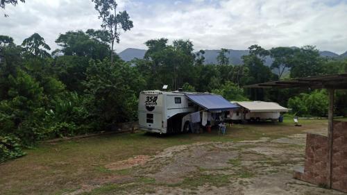 an rv parked in front of a house at Camping Monte Hermom in Ubatuba