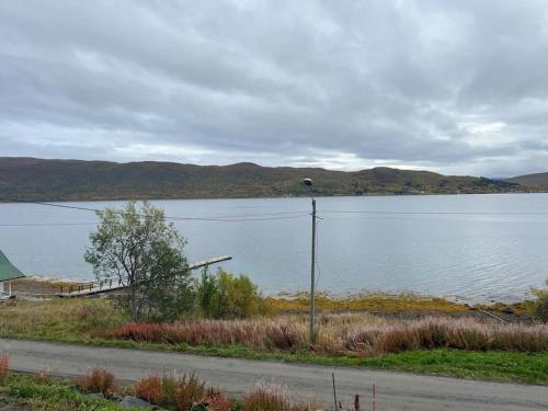 a view of a large lake with mountains in the background at Nydelig villa med havutsikt og utendørs badestamp in Botnhamn