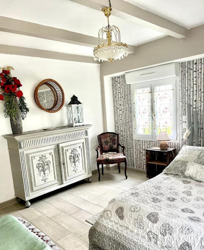 une chambre avec un lit, une chaise et un miroir dans l'établissement Appartement cosy, à Saint-Hilaire-de-Brethmas