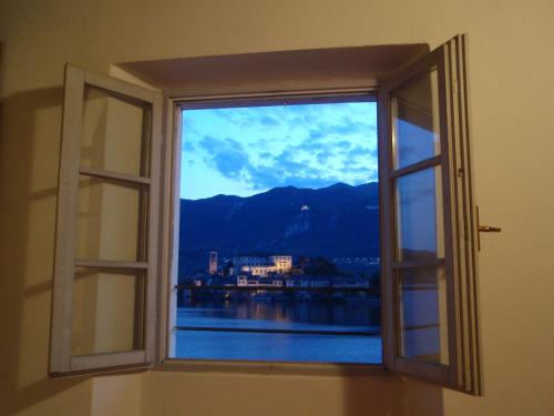 an open window with a view of the water at -Ortaflats- Appartamento l'Isola in Orta San Giulio