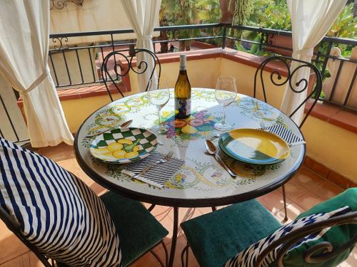 een tafel met een fles wijn en glazen op een balkon bij Case Borgo Vacanze in Letojanni