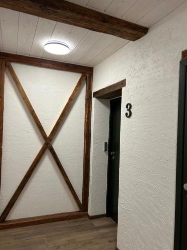 a room with a wooden door and a clock on the wall at Apartamenty pod Belkami in Mikołajki