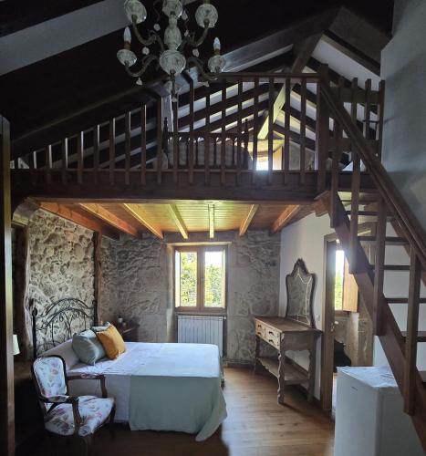 a bedroom with a large bed and a wooden staircase at Campomuiños in A Pobra do Caramiñal