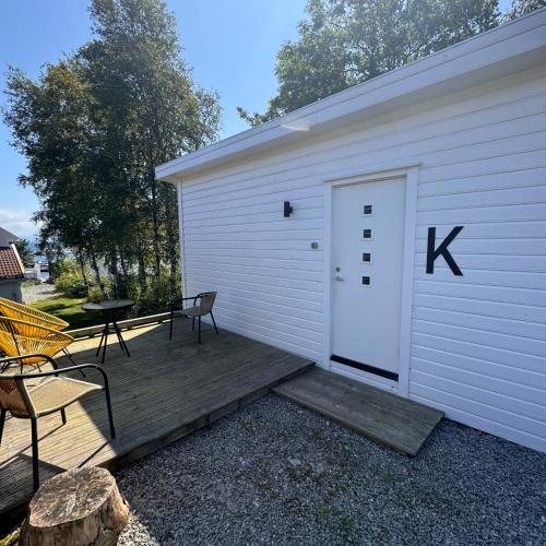 a white garage with a door with a k sign on it at Sjøberg Hotell og Ferie Leiligheter in Østhusvik