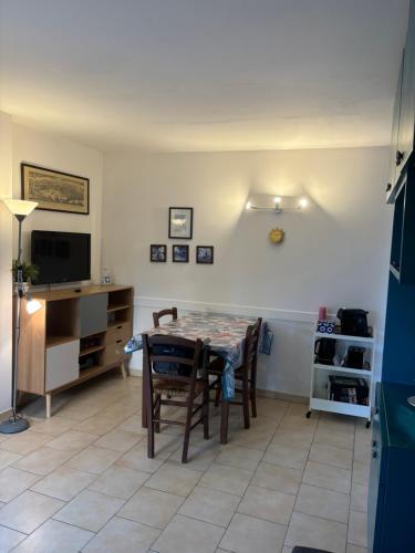 a dining room with a table and a television at Appartamento con giardino a 50 m dal mare in LʼÎle-Rousse