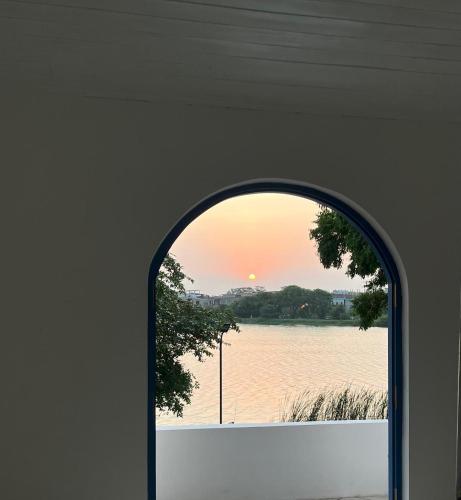 an arched window with a view of a body of water at The Tranquilite' in Anuradhapura