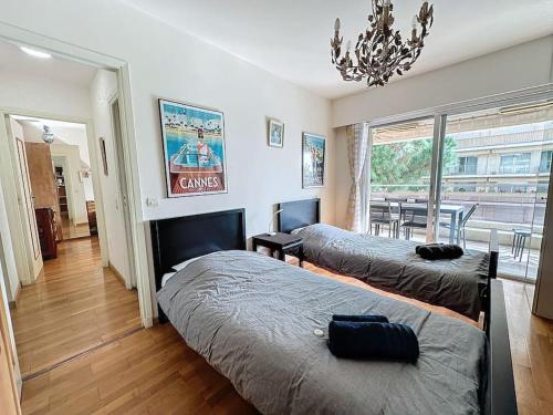 une chambre avec deux lits et un lustre dans l'établissement 85m2 Grandes Terrasses - 2 chambres, à Cannes