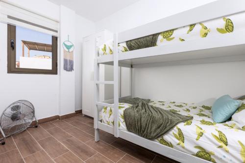 a bunk bed room with a white bunk bed at Home2Book Cozy Beachfront Getaway in Tarajalejo in Tarajalejo