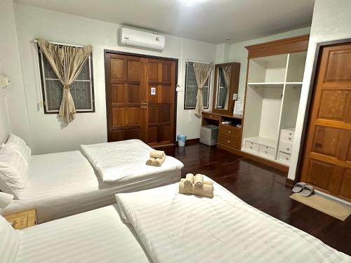 a hotel room with two beds and a mirror at Kong Khong Homestay in Hat Yai
