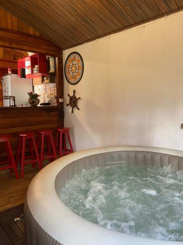 瓜拉雷马Cabana com Jacuzzi em Guararema的带酒吧的客房内的热水浴池