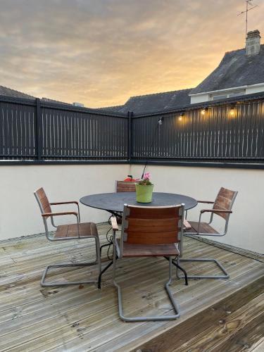 un patio avec une table et des chaises sur une terrasse dans l'établissement Plein centre Auray - Spacieux duplex T2 avec grande terrasse ensoleillée, à Auray