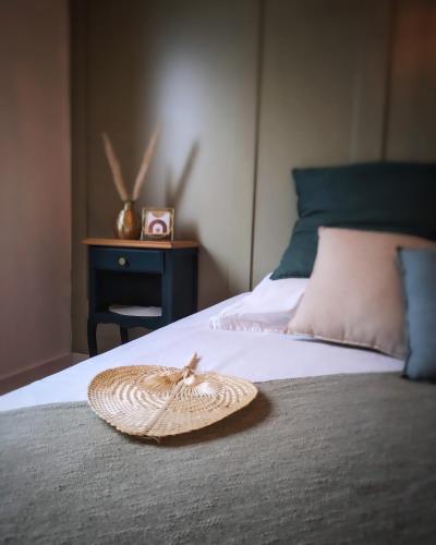 un chapeau en paille assis au-dessus d'un lit dans l'établissement Solen évasion - L'aventurine - maison en Vendée, à La Roche-sur-Yon