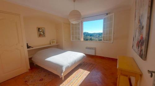 a bedroom with a white bed and a window at Villa Anamour in Draguignan