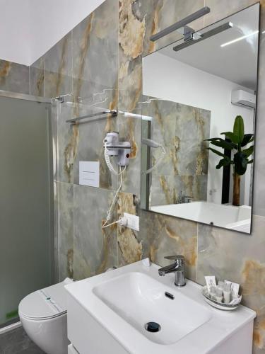 a bathroom with a sink and a toilet and a mirror at Il Ritrovo Spa&Rooms in Naples