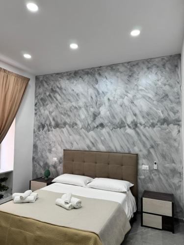a bedroom with two beds and a stone wall at Il Ritrovo Spa&Rooms in Naples
