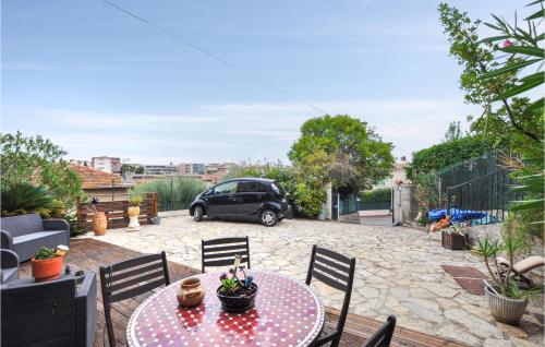 a patio with a table and chairs and a car at Awesome Apartment In Cagnes-Sur-Mer in Cagnes-sur-Mer