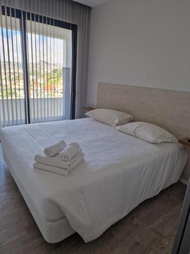 a white bed with two towels on top of it at Ocean Paradise de Santa Luzia in Funchal