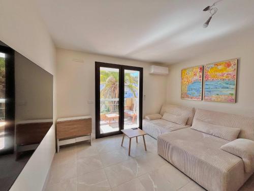 un salon avec un canapé et une table dans l'établissement LE TRAVOLTA avec merveilleuse terrasse, chic et lumineux à deux pas du centre-ville, à Cannes