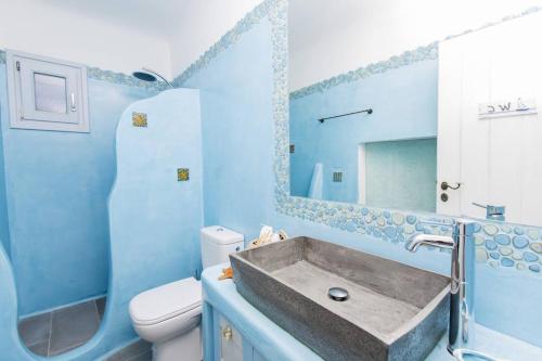 bagno blu con lavandino e servizi igienici di Galani, Immaculate Home with Private Pool & Beach View in Kastraki, Naxos a Kastraki