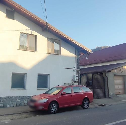 a red car parked in front of a house at Casa Selera Rasnov in Râşnov