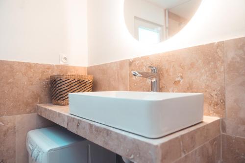 une salle de bain avec un lavabo blanc et un miroir dans l'établissement Le Friendly - Convivial & Chill, à Tours