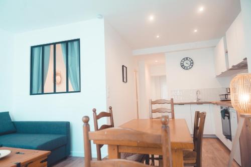 une cuisine et une salle à manger avec une table et un canapé bleu dans l'établissement Le Friendly - Convivial & Chill, à Tours