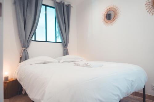 un lit blanc dans une chambre avec une fenêtre dans l'établissement Le Friendly - Convivial & Chill, à Tours