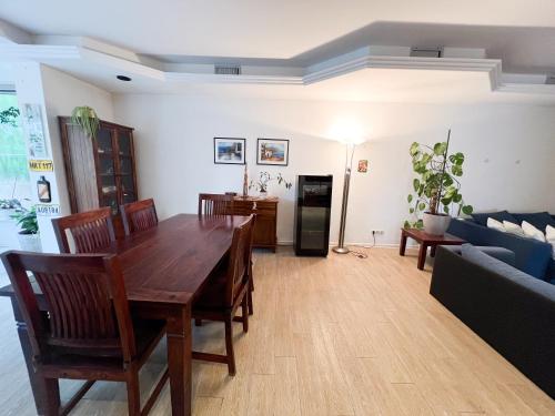 a living room with a wooden table and a couch at Große & voll ausgestattete Apartments, Studios, Doppelzimmer, Workspace, Parkplatz, Netflix, Prime & schnelles Wifi in ruhiger Lage mit Garten in Rudolstadt