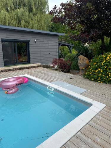 a swimming pool with two frisbees in a yard at le chant de la rivière in Abbeville