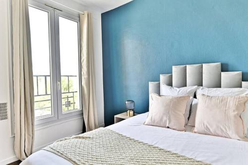 une chambre avec un grand lit avec un mur bleu dans l'établissement Séjour paisible 4 personnes Banlieue Parisienne-II, à Gagny