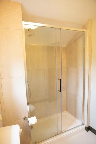 a shower with a glass door in a bathroom at Square & Compass in Two Dales