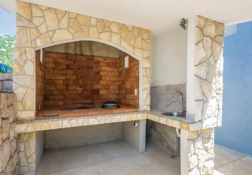 a stone kitchen with a sink and a brick wall at Apartments Ivni in Cesarica