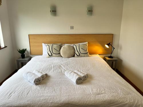 a bedroom with a white bed with towels on it at Sea Whispers - My Charming Costal Retreat in Youghal in Youghal