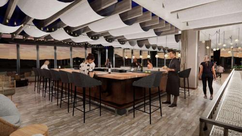 a restaurant with a bar with people standing around it at Black Desert Resort in Ivins