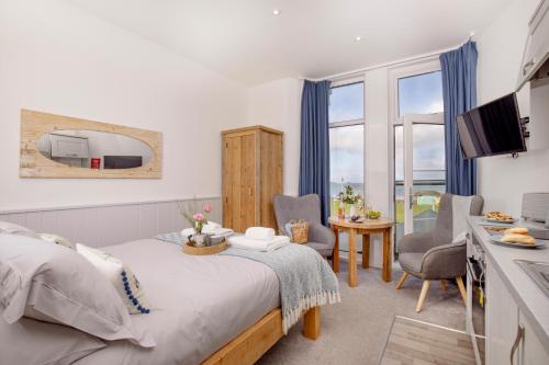 a bedroom with a bed and a table and chairs at Sunnybeach Holiday Apartments in Paignton