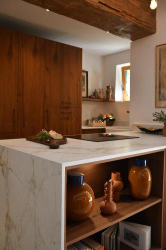 - une cuisine avec un comptoir en poterie dans l'établissement La Piscine dans la Foret, à Gordes